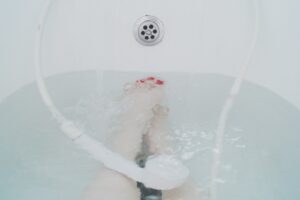 Piedi in un pediluvio con tè nero, rimedio naturale contro la puzza.